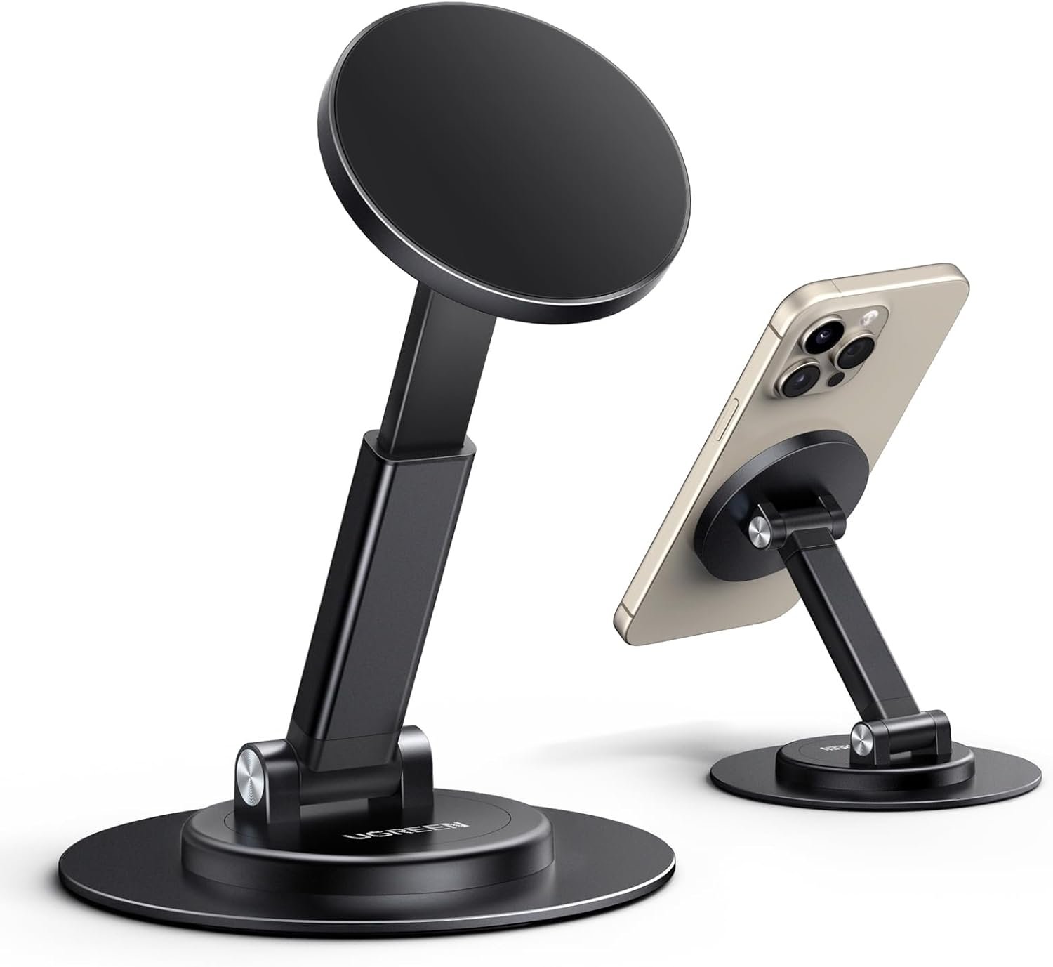 Black aluminium UGREEN magnetic phone stand holding an iPhone at an angle on a desk, with a weighted round base.