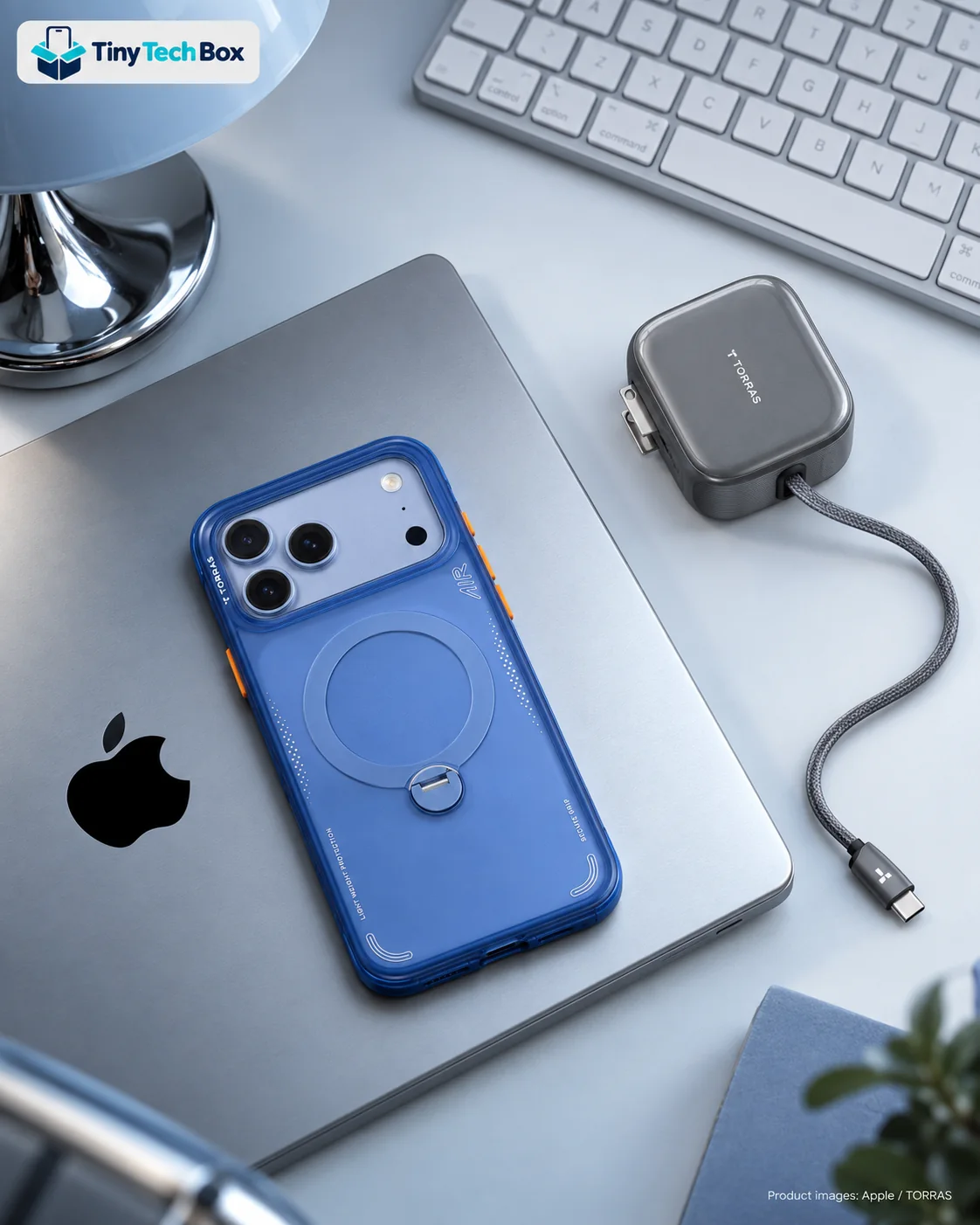 Glacier iPhone 18 Pro Max in an Arctic Blue TORRAS Q3 Air case on a silver laptop, beside a graphite grey TORRAS FlexLine Pro charger with its cable extended